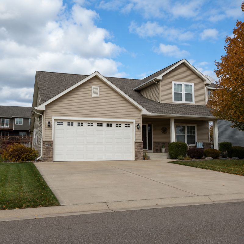 Photorealistic St. Joseph, MN home with a white garage door, concrete driveway, and residential landscaping, representing After Hours Garage Door service.